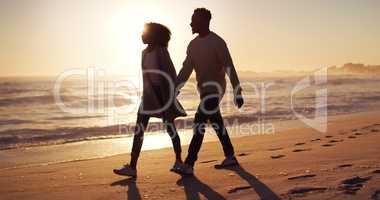 Were going where love leads us. Full length shot of an affectionate young couple taking a stroll on the beach at sunset.