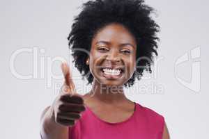 Nothing but positivity. Studio portrait of an attractive young woman giving a thumbs up against a grey background.