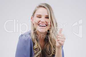 I have to agree. Studio portrait of an attractive young woman giving a thumbs up against a grey background.