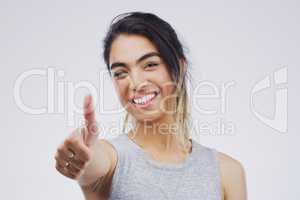 Id back you. Studio portrait of an attractive young woman giving a thumbs up against a grey background.