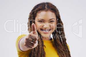 Expressing her approval. Studio portrait of an attractive young woman giving a thumbs up against a grey background.