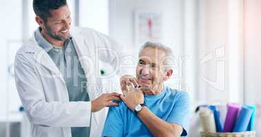 I can already feel the pain going away. a male doctor doing some physiotherapy with a senior patient.