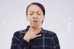 It hurts so bad every time I cough. Studio shot of a young woman suffering with a sore throat against a grey background.