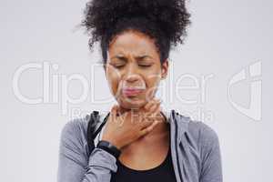 Clearing my throat before I say this. Studio shot of a young woman suffering with a sore throat against a grey background.