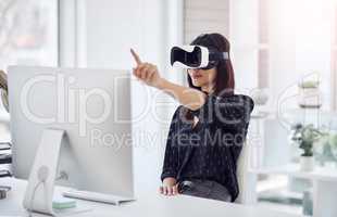 Her business knows no bounds. a young businesswoman wearing a VR headset while working in her office.