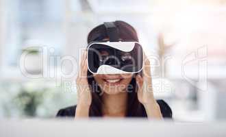 Innovation drives the world, as so it should your business. a young businesswoman wearing a VR headset while working in her office.