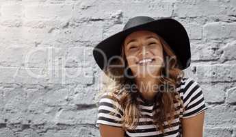 Sunny days in the city are always the best. Portrait of an attractive young woman posing against a brick wall outdoors.