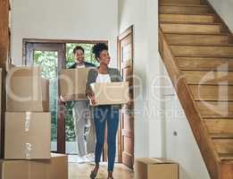 Interracial couple moving into a new modern house, carrying boxes and arriving home together. Happy, excited and smiling husband and wife walking, entering and relocating after buying an apartment