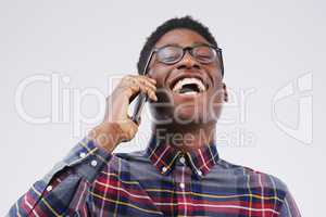 Keep in touch and keep the laughter flowing. Studio shot of a young man using a mobile phone against a grey background.