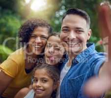 Lets capture our cute family moments. Cropped portrait of a happy family taking a selfie at the park.