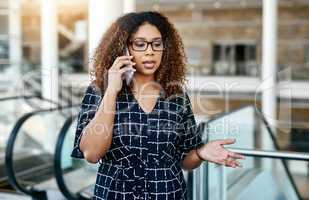 She knows the right things to say to win the deal. an attractive young businesswoman taking a phonecall while walking through a modern workplace.