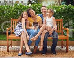 Great times with our favourite member of the family. Full length portrait of a happy family playing with their dog on a bench at the park.