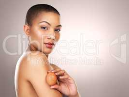 Start using them in your beauty routine. Studio shot of a beautiful young woman holding a egg against her skin.