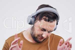 Getting groovy. Studio shot of a handsome young man dancing against a grey background.