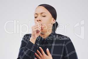 Feels like a chest infection. Studio shot of an attractive young woman coughing against a grey background.