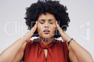 Everybody hold on for a minute, I need to think. a young woman holding her head while suffering from a headache against a grey background.