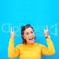 Make sure you leave your comments in the section above. Cropped portrait of a happy young woman pointing up against a blue background.