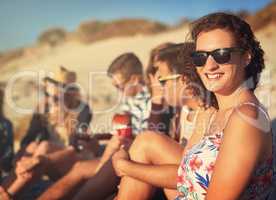 Time spent with friends is time well spent. an attractive young woman hanging out with her friends on a summers day at the beach.