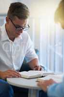 Were seeking for some divine intervention. two young businessmen reading their bibles at work.