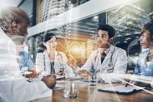 Lets discuss diagnosis. a group of doctors having a meeting in a hospital.