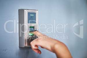 The safest form of entry. an unrecognizable woman using a fingerprint scanner to enter a building.