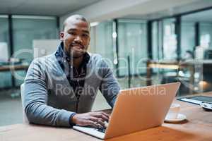 Success always boils down to your hard work and determination. Portrait of a handsome young businessman working on a laptop in his office.