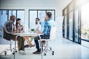 This is what you call a productive environment. a group of young businesspeople discussing ideas with each other during a meeting in a modern office.