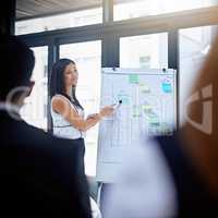 This figure will put a smile on everyones face. a young businesswoman giving a demonstration on a white board to her colleagues in a modern office.