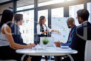 Shes got everyones attention. a young businesswoman giving a demonstration on a white board to her colleagues in a modern office.