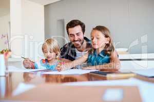 Your presence plays a big role in their lives. a young father helping his two small children with their homework at home.