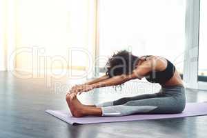 More stretching, less stressing. a beautiful young woman practising yoga in a studio.