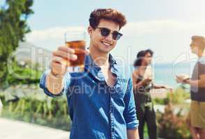 I hope everyone is enjoying their holidays as well. Portrait of a handsome young man raising up his glass for a toast while relaxing outdoors with his friends.