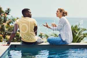 She always has a long story to tell. Rearview shot of a young couple enjoying drinks together while relaxing outdoors on holiday.