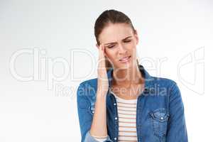 Where did this headache come from. Studio shot of a young woman suffering from a headache against a grey background.