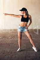 Shes got a point to prove. an attractive young female street dancer practising out in the city.
