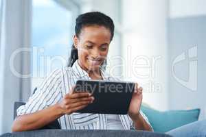 Browsing her all-time favourite websites. a young woman using a digital tablet at home.