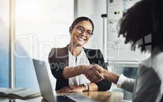 Im glad to be able to assist. two businesswomen shaking hands in an office.