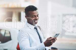 His plans for success never fail. a handsome young businessman using a cellphone in the city.