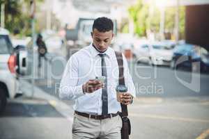 Connectivity is everything for a man on the move. a handsome young businessman using a cellphone in the city.