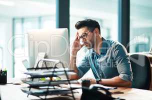 Stress, anxiety and worry with a business man feeling frustrated, irritated and annoyed with work and deadlines. Unhappy and negative male employee suffering from a headache or migraine in his office