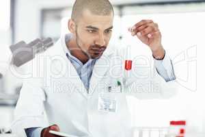 Scientist with test tube for medical research, healthcare or science testing, checking DNA blood sample. Serious laboratory professional searching for marburg virus, ebola or monkeypox cure