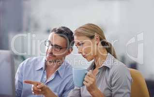 Professional business people working together on a computer, doing quality assurance and looking at information. A corporate man and woman thinking of ideas and analyzing investment statistics