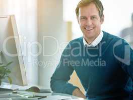 Happy, confident and smiling businessman sitting at his desk and feeling satisfied with his career and job choice. Portrait of a motivated and proud male entrepreneur working to grow his startup