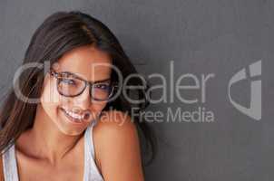 Cool, confident and beautiful woman wearing glasses and smiling with a grey wall and copy space. Face of a cheerful, stunning, attractive and happy female feeling good and showing a positive attitude