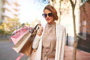 Fashion, style and shopping bags while out on an urban city street and enjoying a spending spree. Portrait of trendy woman showing of her purchase after buying items on discount during a sale