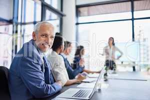 Happy CEO, boss or chairman looking confident in a team meeting at work. Portrait of a proud employee with colleagues as they discuss new innovative plans and strategy in a corporate office