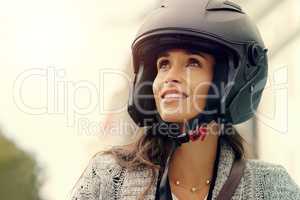 See the world for what it truly is, beautiful. Closeup shot of an attractive young woman wearing a helmet and riding her scooter through the city.