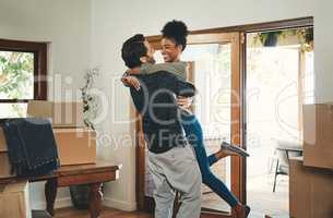 Homeowner couple celebrating, hugging and cheering in new home as real estate investors, buyers and owners. Fun interracial man and woman looking excited, happy and cheerful while embracing by boxes
