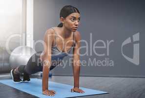 Every decision in the end involves balance and sacrifice. an attractive young woman busy doing stretching exercises on her gym mat at home.