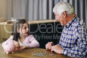 Golden pearls of wisdom from granddad. a little girl learning about money from her grandfather.